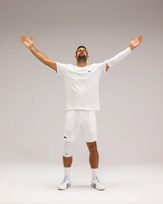 Novak Djokovic med armene i været, i hvit Arm Sleeve og Knee Sleeve