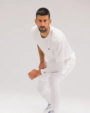 Novak Djokovic på huk i hvite Leg Sleeves og Arm Sleeve