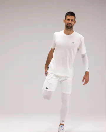Novak Djokovic løfter det ene kneet, i hvite Leg Sleeves