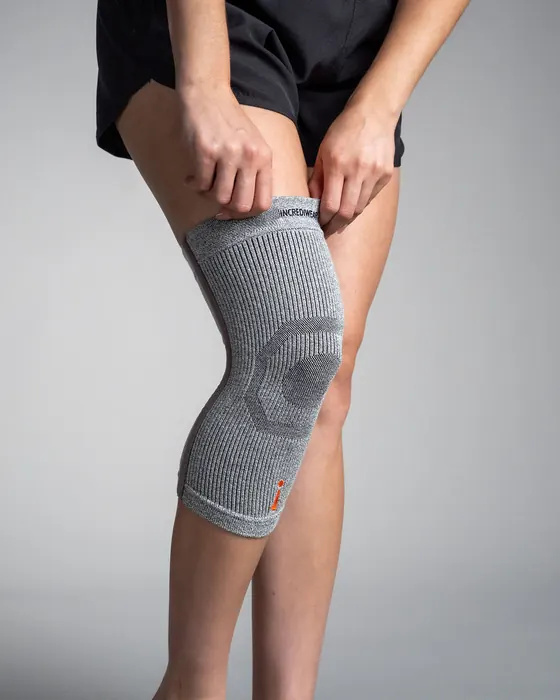 Grå Knee Sleeve trekkes på plass over kneet