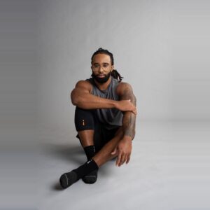 Sort Knee Sleeve på en mann som sitter på gulvet