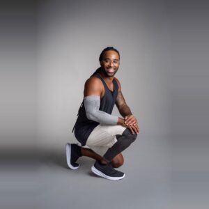 Grå Elbow Sleeve på en mann som sitter på huk