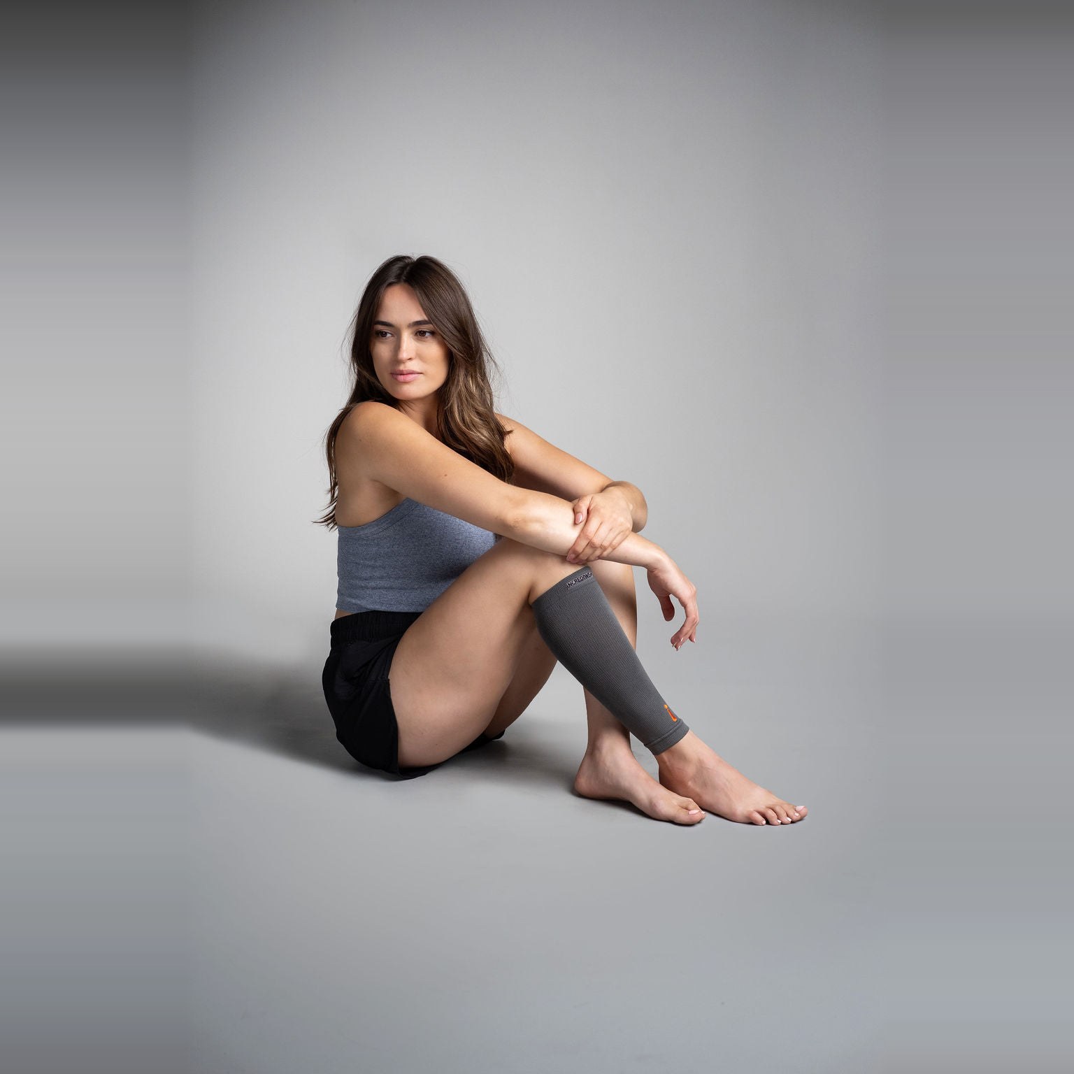 Calf Sleeve på en kvinne som sitter med bøyde knær
