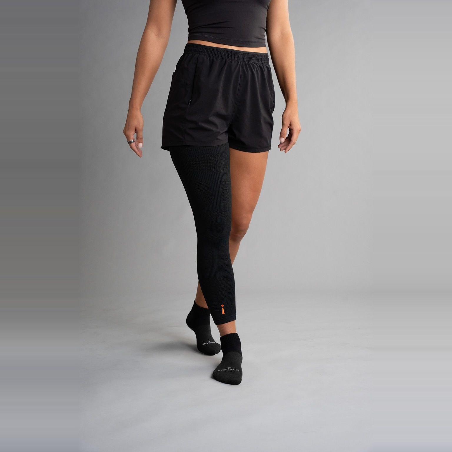 Sort Leg Sleeve på det ene beinet, på en kvinne som går mot kameraet
